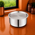 Triply stainless steel container with matching lid placed on a modern orange kitchen countertop near a window. Premium food-grade mirror-finish storage container designed for storing cooked food, rice, dal, curries, vegetables, and everyday kitchen essentials. Durable, rust-resistant, hygienic, and suitable for daily household use.