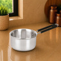 Stainless steel saucepan with black handle on a beige surface