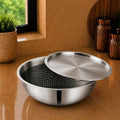 Stainless steel pot with lid on a wooden surface