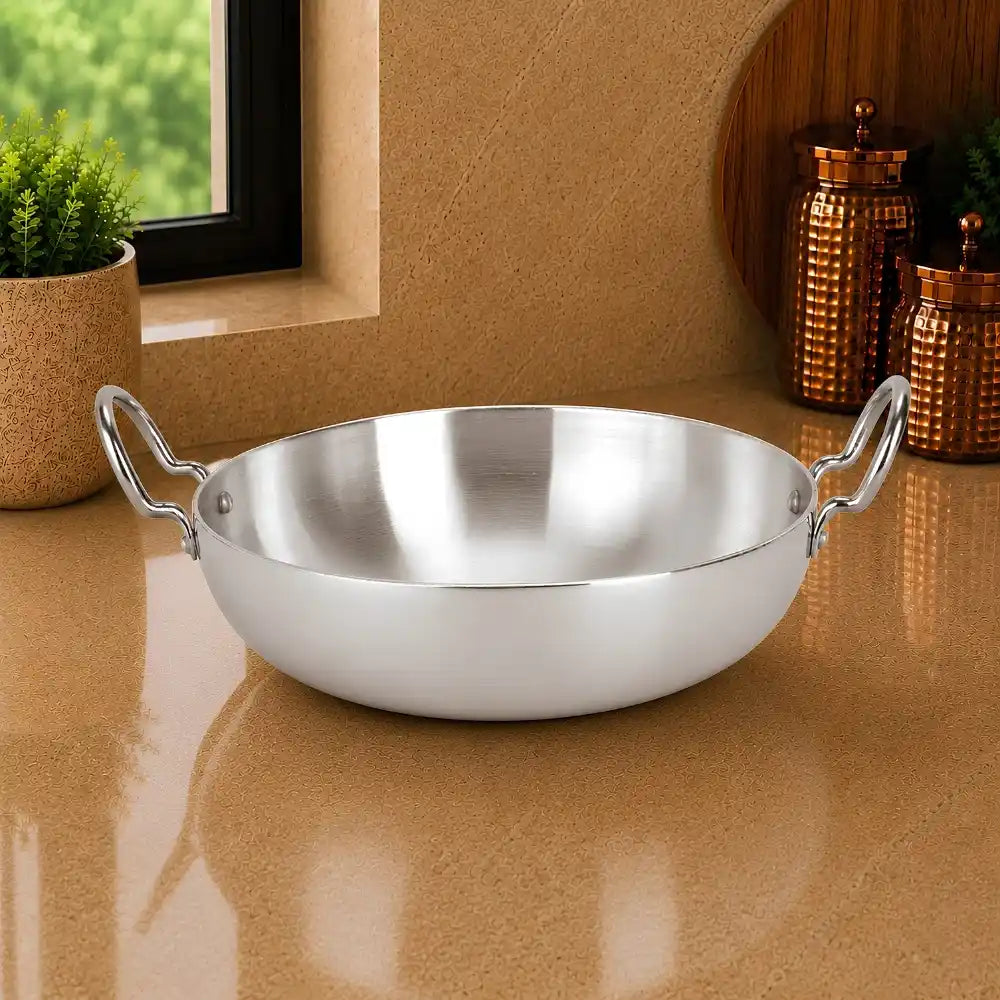 Stainless steel wok on a reflective surface with a neutral background