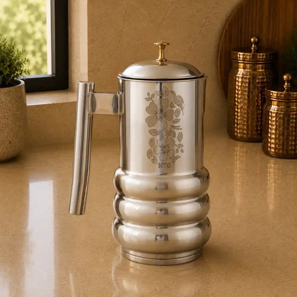 Silver coffee press with floral design on a beige surface