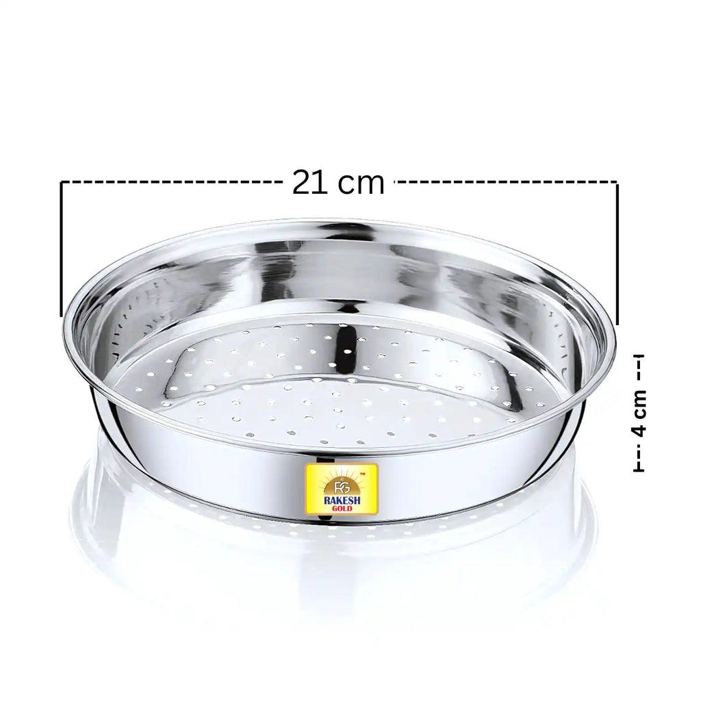 Stainless steel chalni (strainer) on a warm modern kitchen countertop with a window view, decorative plant, and copper storage jars.