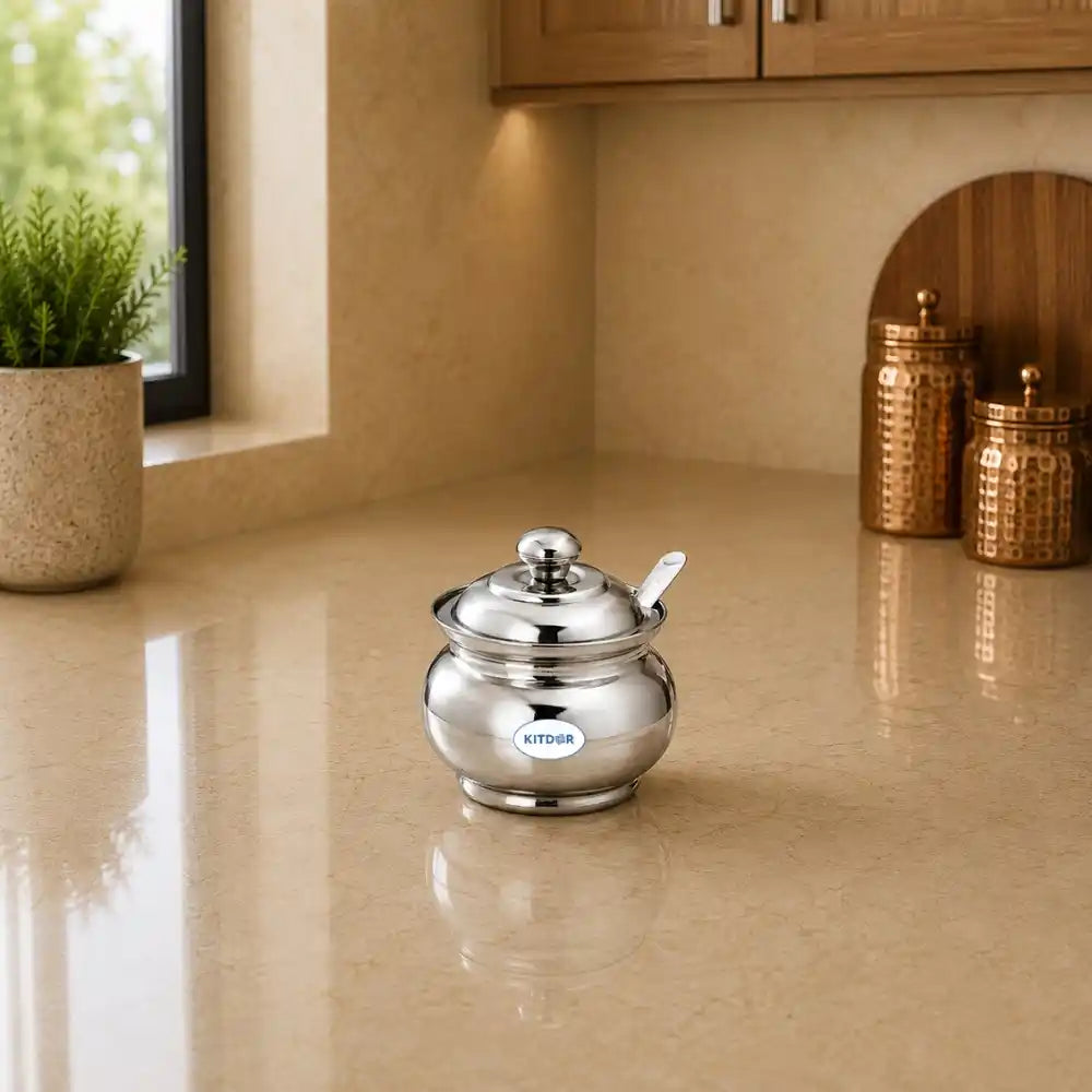 Silver sugar bowl with a spoon on a beige kitchen counter