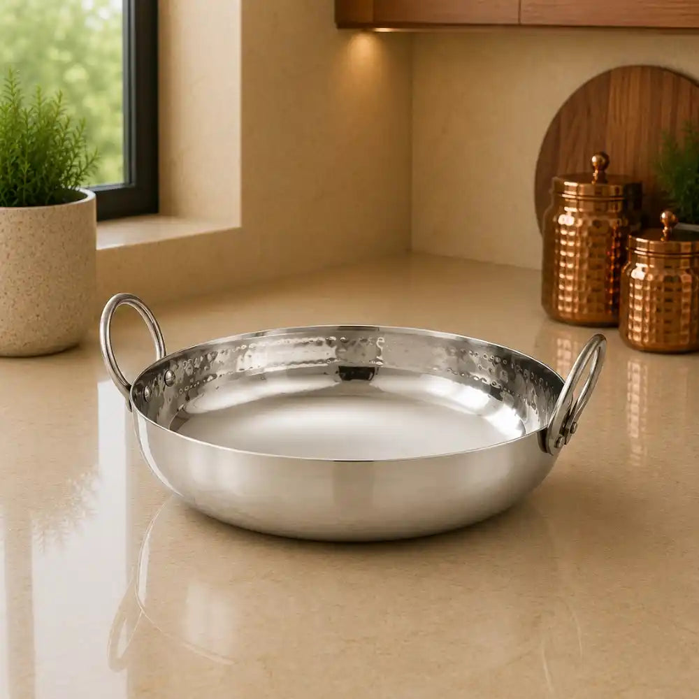 Silver pot on a beige countertop with a kitchen setting in the background