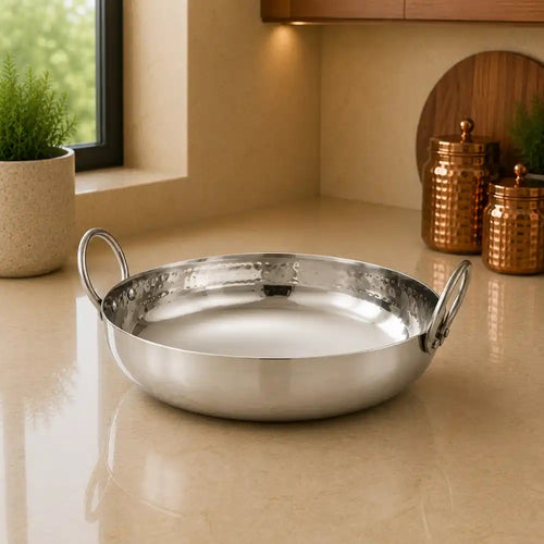 Silver pot on a beige countertop with a kitchen setting in the background