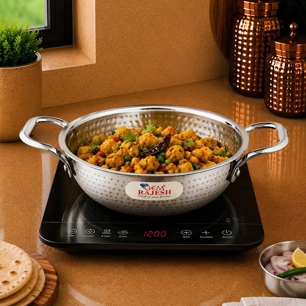 Stainless steel wok with food on a digital stove, brand 'Gem Rajesh' visible