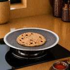 Flatbread on a round, textured metal pan over a stove