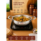 Silver cooking pot with food on an induction cooktop, branded 'Rajesh', with a wooden background and product packaging.