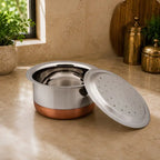 Stainless steel pot with a perforated lid on a kitchen counter