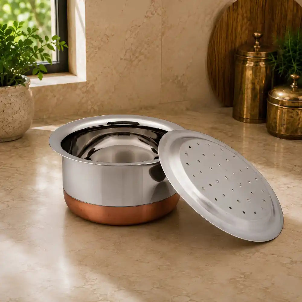 Stainless steel pot with a perforated lid on a kitchen counter