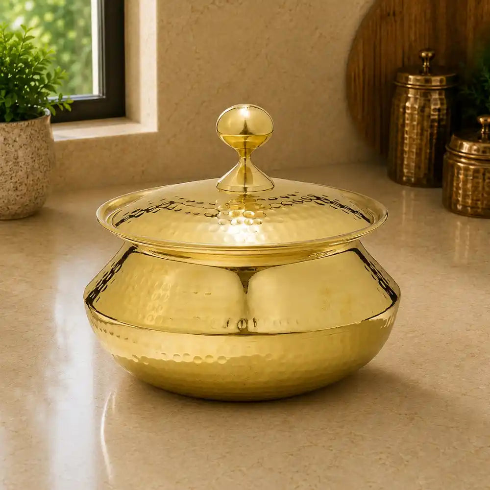 Gold decorative pot with a lid on a beige surface
