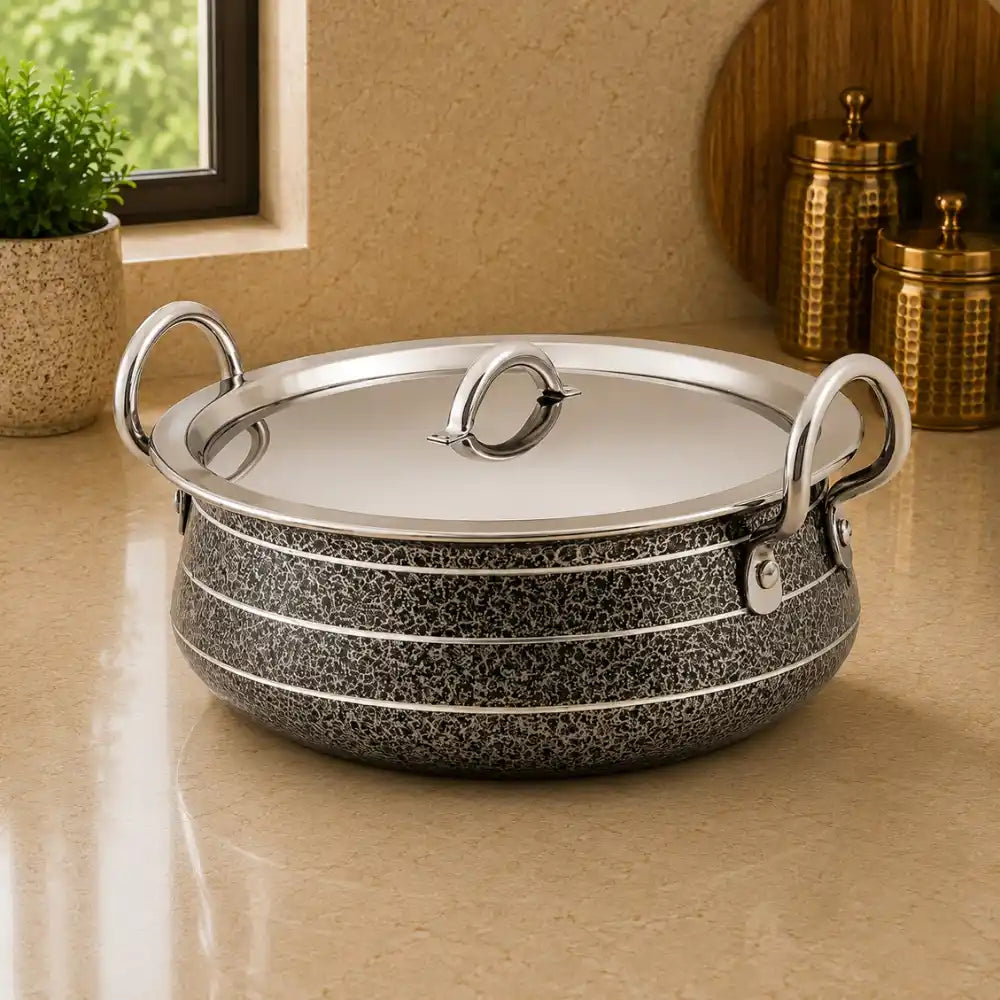 Speckled cookware with silver lid on a beige surface