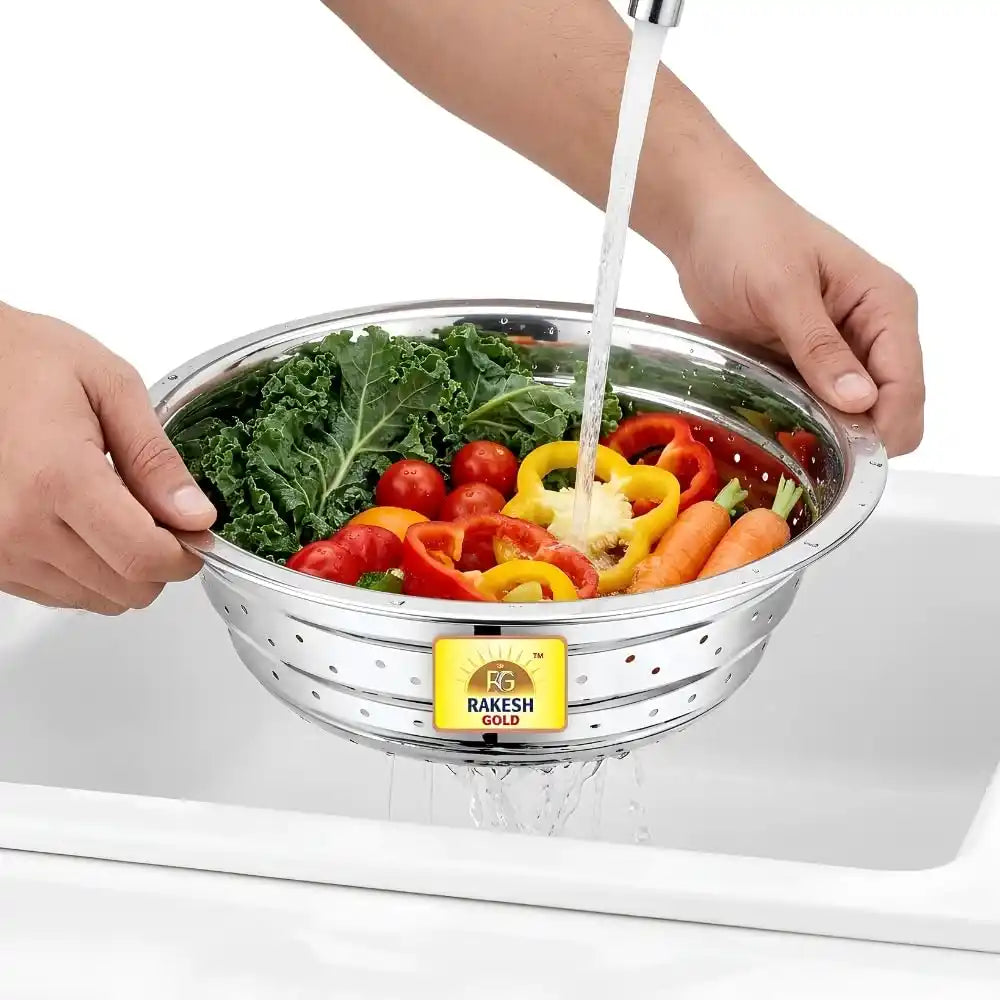 Stainless steel vegetable washing chalni with perforated design on a modern kitchen countertop, ideal for rinsing fruits, vegetables, rice, and pasta.