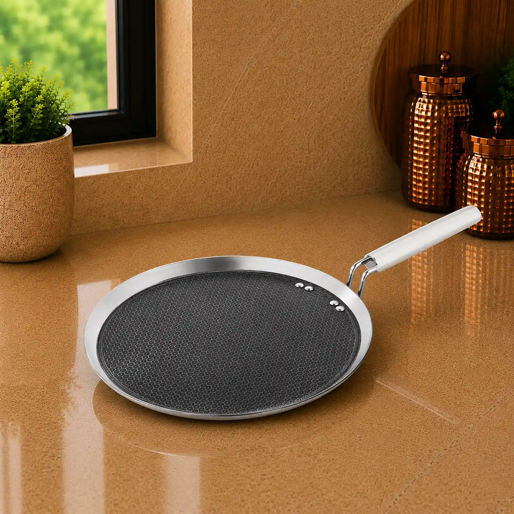 Frying pan with a white handle on a reflective surface