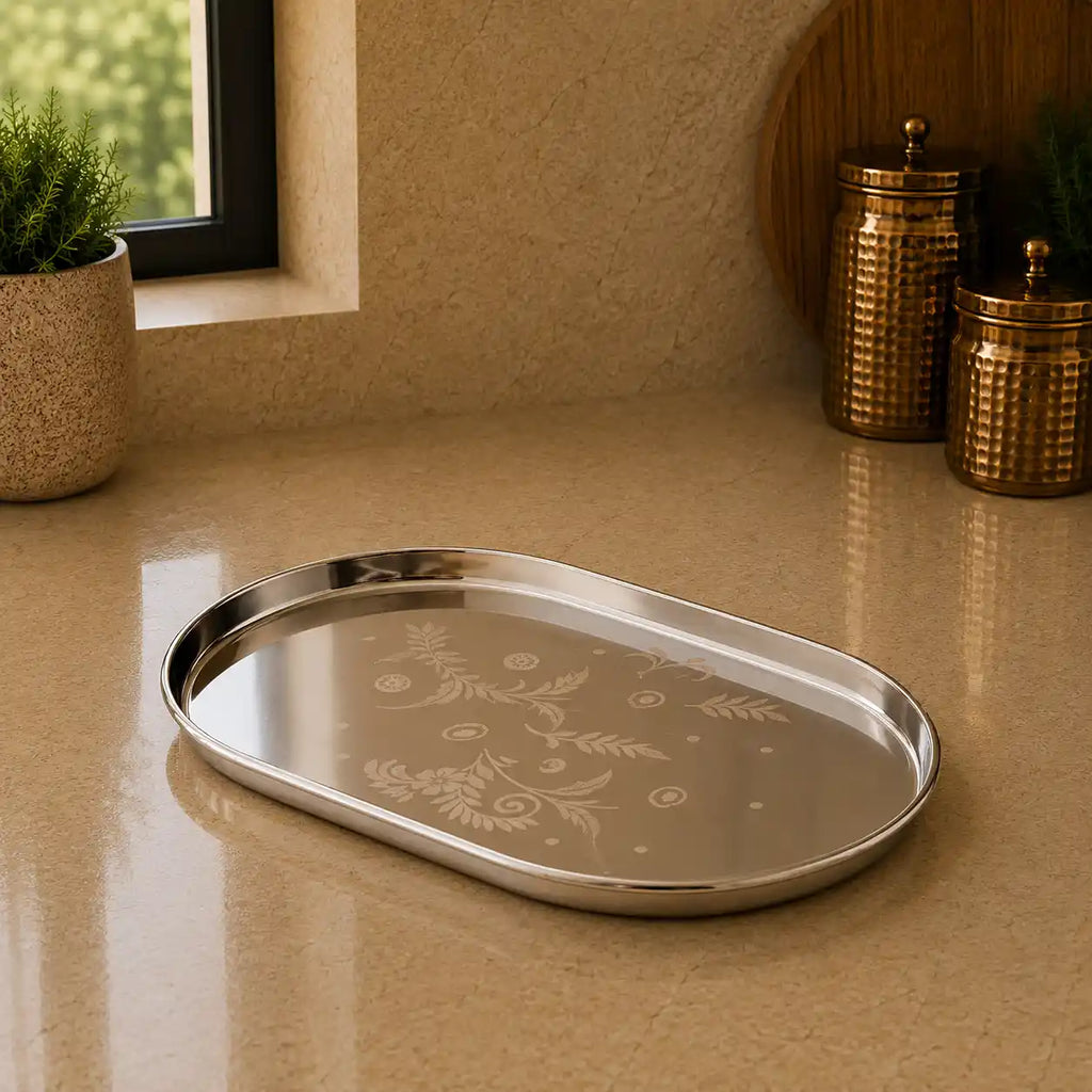 Silver tray with floral patterns on a beige surface