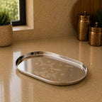 Silver tray with floral patterns on a beige surface