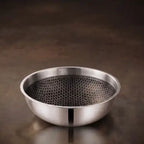 Tri-Ply stainless steel tasla with a honeycomb cooking surface and sturdy side handles, displayed on a dark brown background. Heavy-duty deep cooking vessel suitable for gas and induction cooktops.