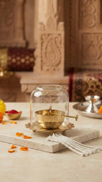 Decorative glass container with a gold interior on a stone surface with a blurred background