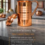 Polished copper water jug with lid and handle placed on marble kitchen countertop
