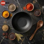 Cast iron mini kadai filled with hot dal tadka on rustic wooden dining table with steam rising