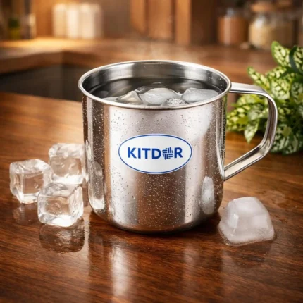 Stainless Steel Mug with Handle filled with ice water on wooden table in kitchen